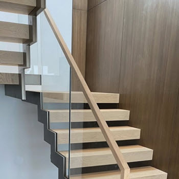 Concealed glass hardware in the ends of the stair tread beneath the zig zag stringer.