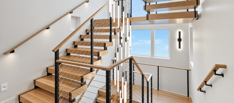Modern floating staircase with white oak treads and custom cable railing