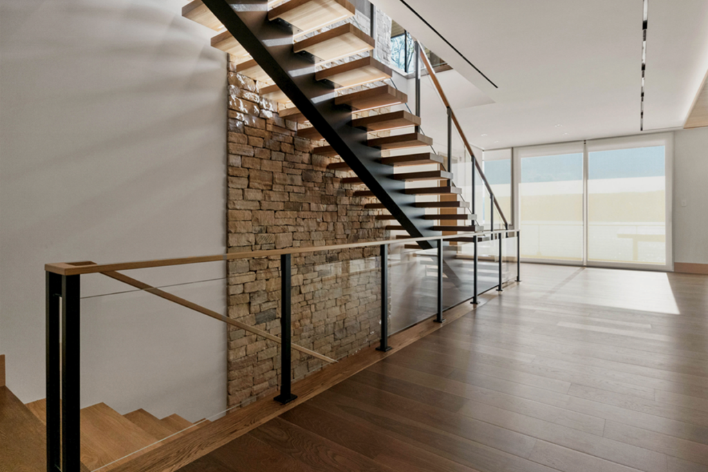 Minimalist floating stairs with single stringer, night lighting built into the oak treads and glass railings.