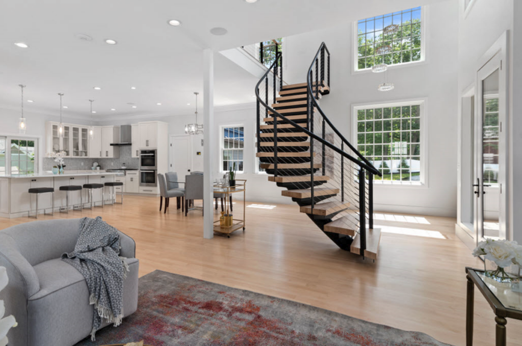 Curved stairs with round mono stringer with wood treads and cable railings.