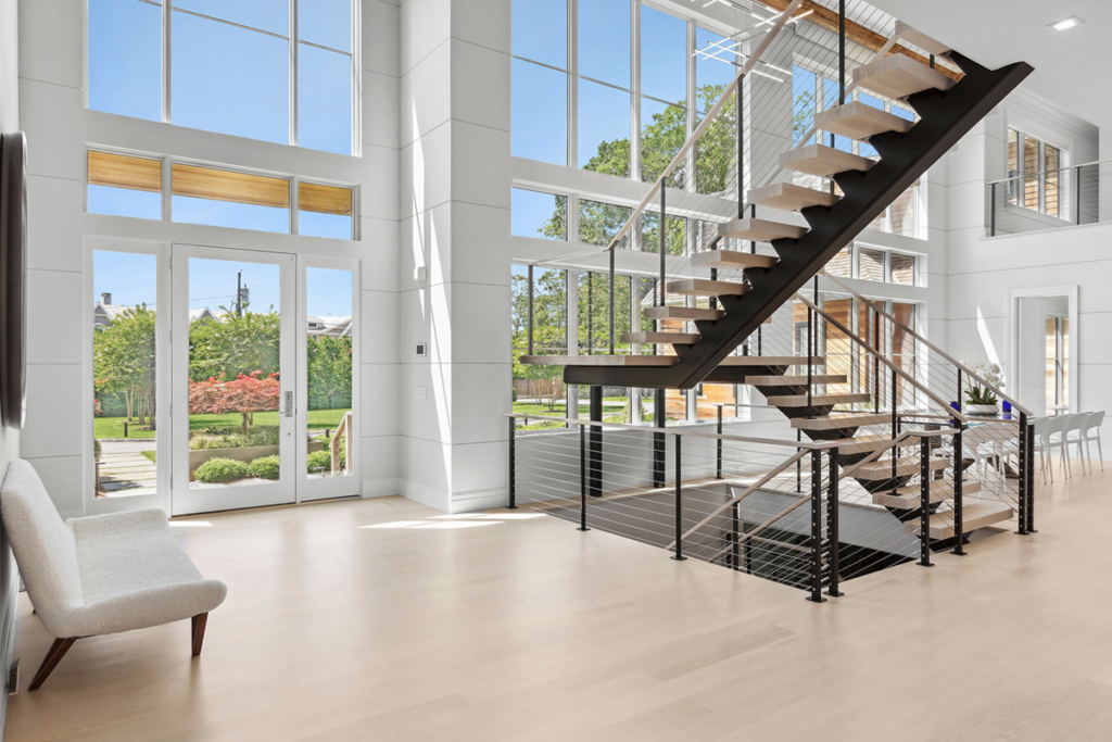 Floating mono stringer stair and landing with cable railings and white oak treads.