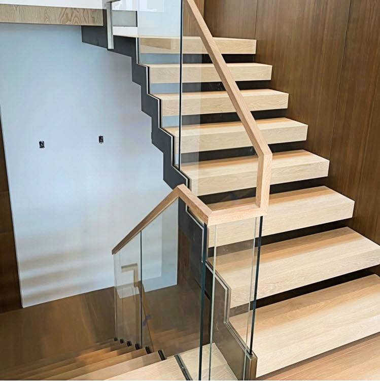 Glass railing with zig zag stringer and white oak treads. The glass railing is embedded in the stringers creating a clean minimalist aesthetic.