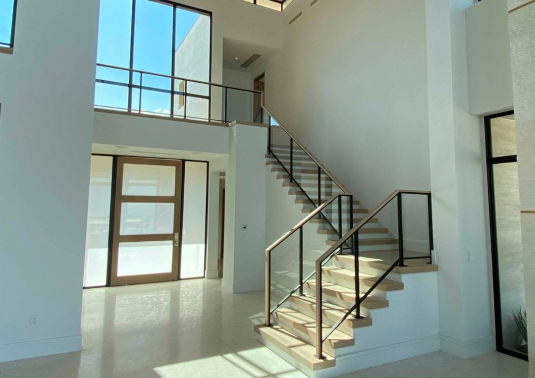 Modern glass stair railing with slim steel frame and wood treads.